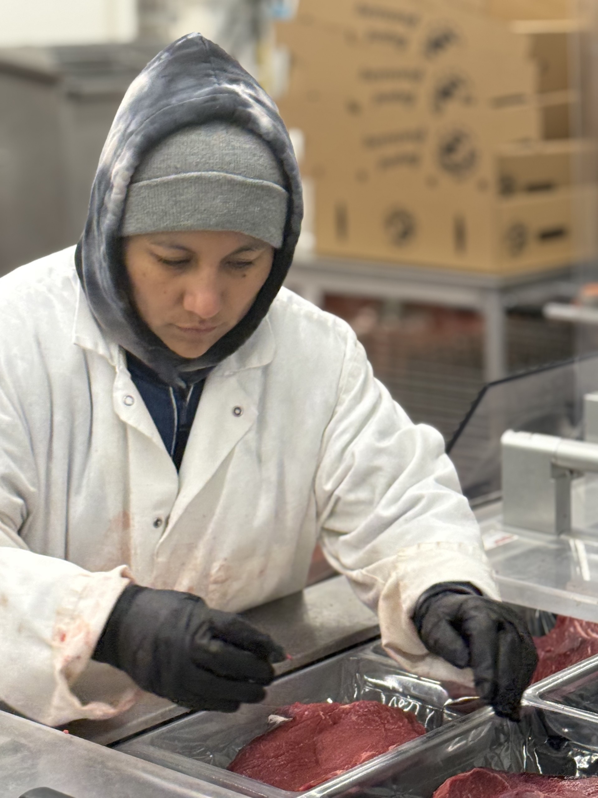 Skilled worker trimming beef in a meat-processing facility